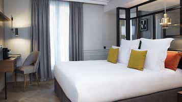 A modern hotel room with a large bed, a desk, and a chair.