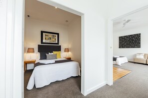 Relax in a serene space with a large bed, two bedside tables, and a cozy seating area.