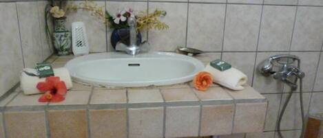 A bathroom with a white sink, a shower, and a towel rack.