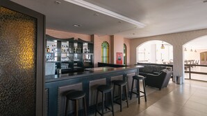 A bar area with stools, a bar counter, and a wine rack. - Hotel das Figueiras (Sao Lourenco do Sul)