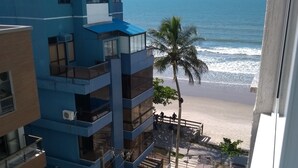 A multi-story building with balconies overlooking a beach. - Nice apartment, right on the beach and in a great location. (Meia Praia Itapema)