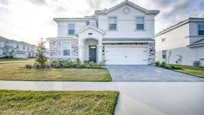 A modern two-story house with a garage, a well-maintained lawn, and a driveway. - 1574 Observer Lane (Davenport)