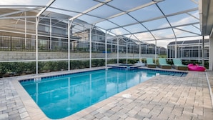 A pool area with a glass-enclosed structure, lounge chairs, and a pool edge. - 1574 Observer Lane (Davenport)