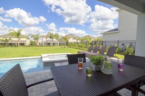 A patio with a pool, outdoor furniture, and a clear view of the neighborhood. - 7711 Fairfax Drive (Kissimmee)