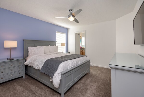 A bedroom with a bed, nightstands, a ceiling fan, and a dresser. - 8489 Oasis Key Cove (Kissimmee)