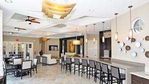 A spacious hotel lobby with a central bar area, seating arrangements, and a modern ceiling design. - Solterra Five-bedroom (Davenport)