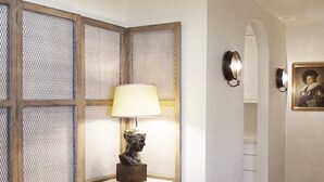 Un pasillo con un banco blanco, una lámpara y un cuadro en la pared.