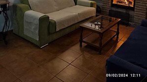 Una sala de estar acogedora con chimenea de piedra, un sofá y una mesa de centro.