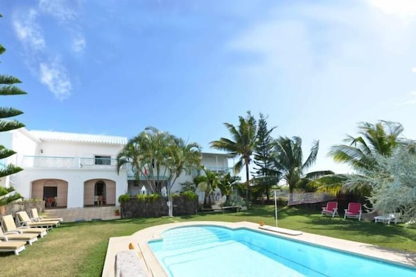 Les 2 villas donnent sur une pelouse dans un grand jardin au milieu la piscine