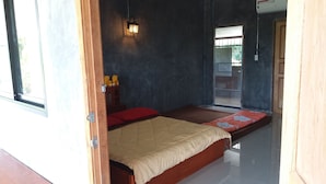 A room with a bed, a small table with two teddy bears, a nightstand, and a wall-mounted light fixture. - Baan Saun Homestay by Lamyai Khunmae (Ban Thi)
