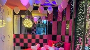 A room with a checkered wall, a bed with a red cover, heart-shaped balloons, and a swing. - Quynh Huong Hotel (Ho Chi Minh City)