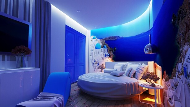 A modern bedroom with a circular bed, a blue accent wall, and a mural of a coastal scene. - Quynh Huong Hotel (Ho Chi Minh City)