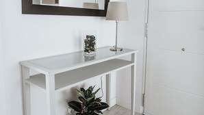 A white console table with a mirror above it, a lamp, and a potted plant on a woven tray. - Semi-detached house 5 'walk from the beach (La Garita, Telde, Las Palmas)