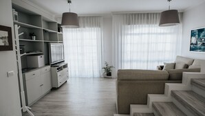 A modern living room with a sofa, a TV, and a staircase. - Semi-detached house 5 'walk from the beach (La Garita, Telde, Las Palmas)