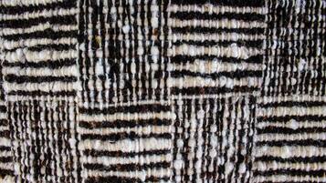 Un gros plan d’un tissu texturé orné d’un motif à rayures.