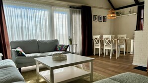 Ein Wohnzimmer mit einer Couch, einem Couchtisch und einem Essbereich mit Stühlen und Tisch.