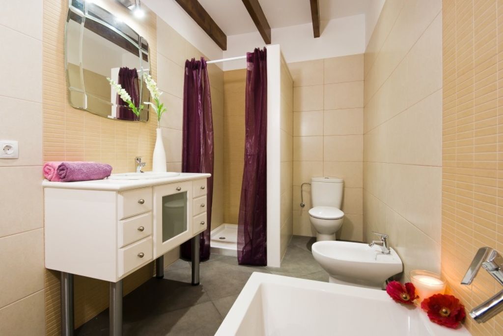 Een bad/douchecombinatie, een haardroger, een bidet, handdoeken