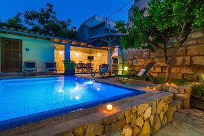 A swimming pool with a stone border, outdoor seating, and a stone wall. - Can Vall, Prima for 2 families with children (Petra)