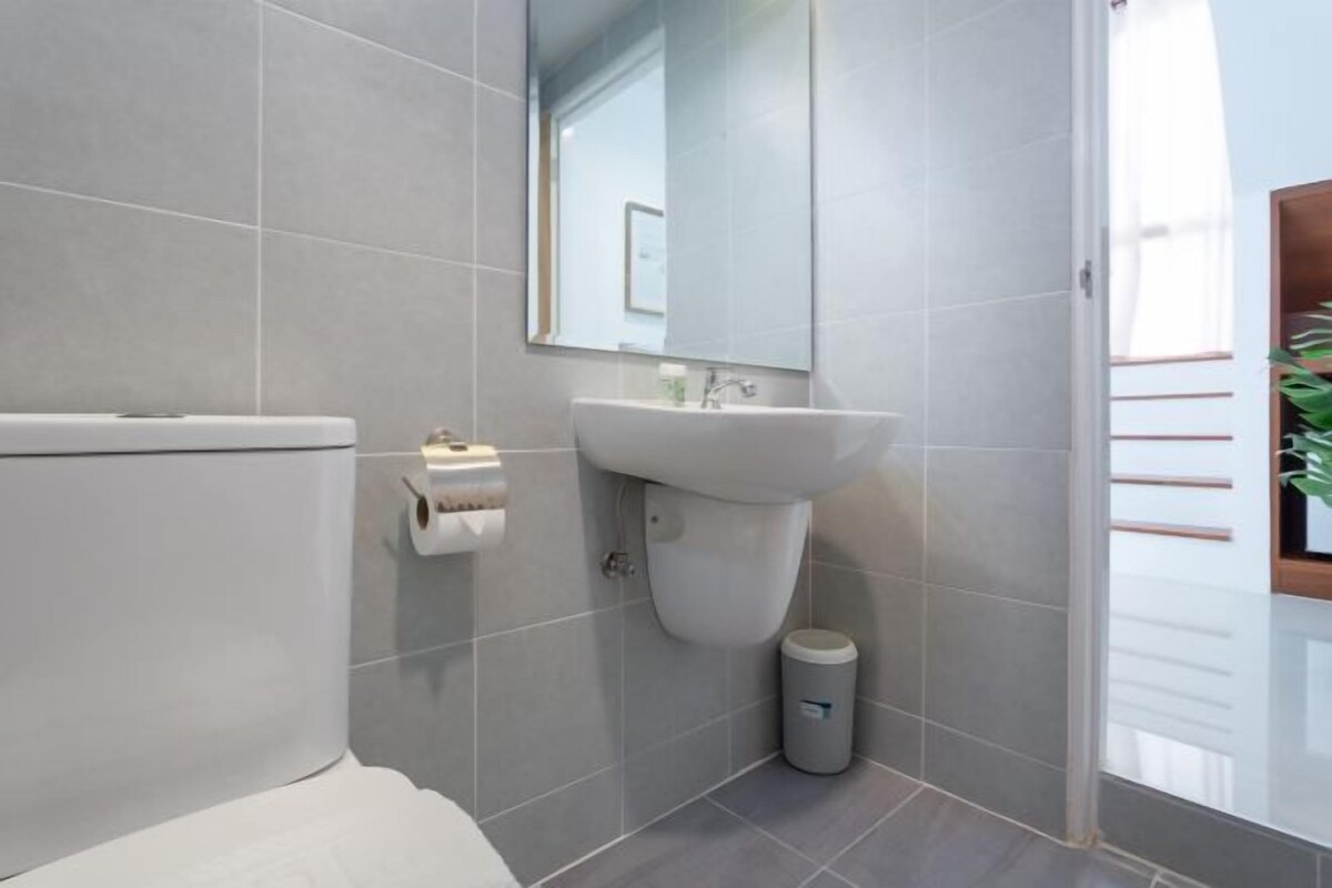 A modern bathroom with a toilet, sink, and mirror.