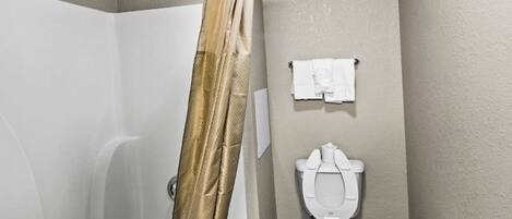 A bathroom with a shower, toilet, and towel rack.