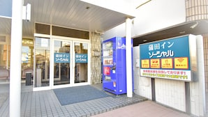 A building entrance with a vending machine and a signboard. - Kamata In Social (Tokyo)