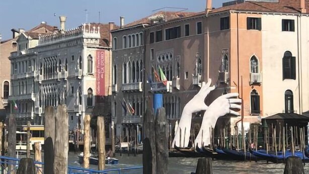 A canal with historic buildings, wooden posts, and boats. - Ca Baglioni (Venice)