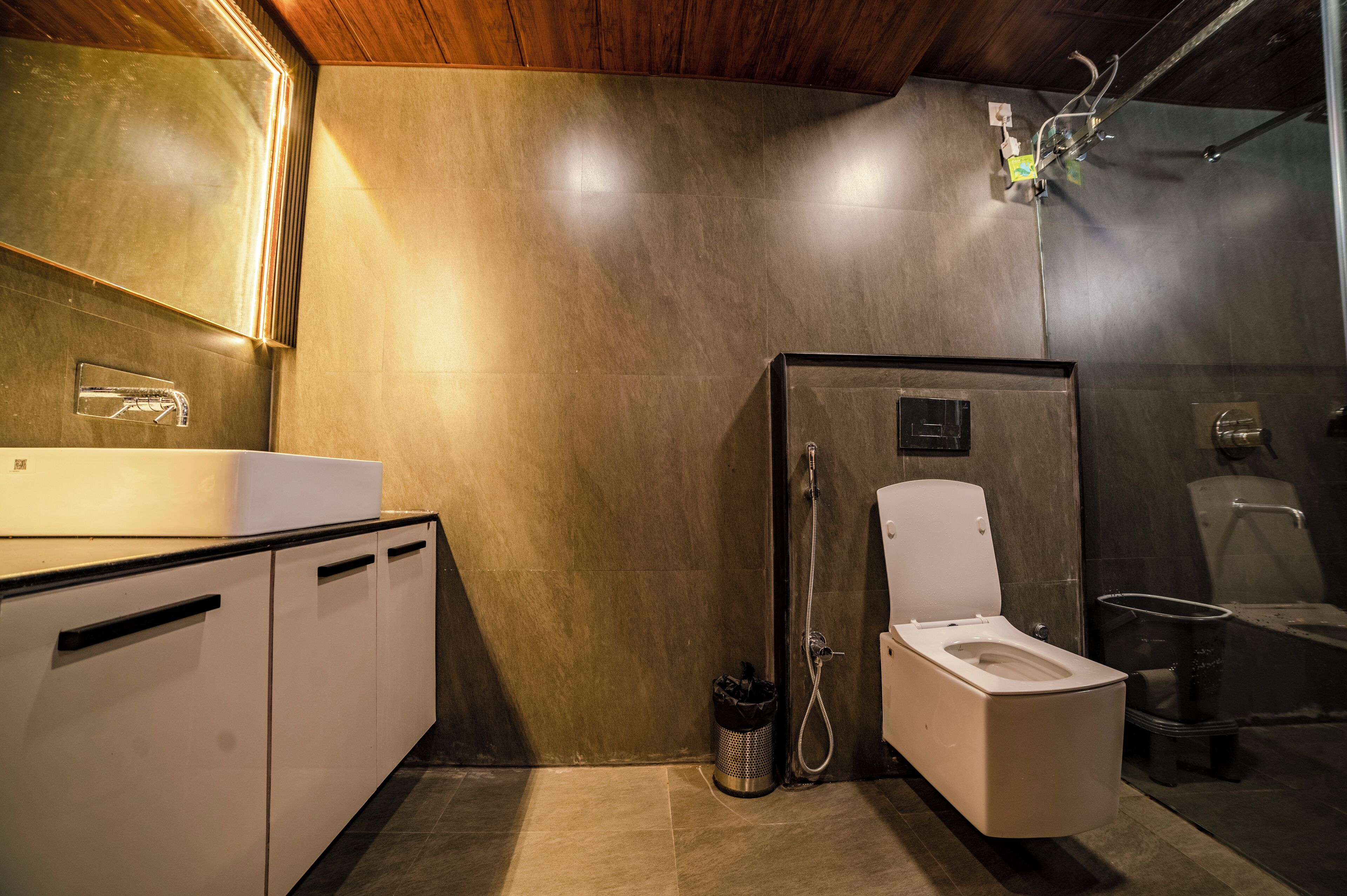 A modern bathroom with a shower, toilet, and sink.