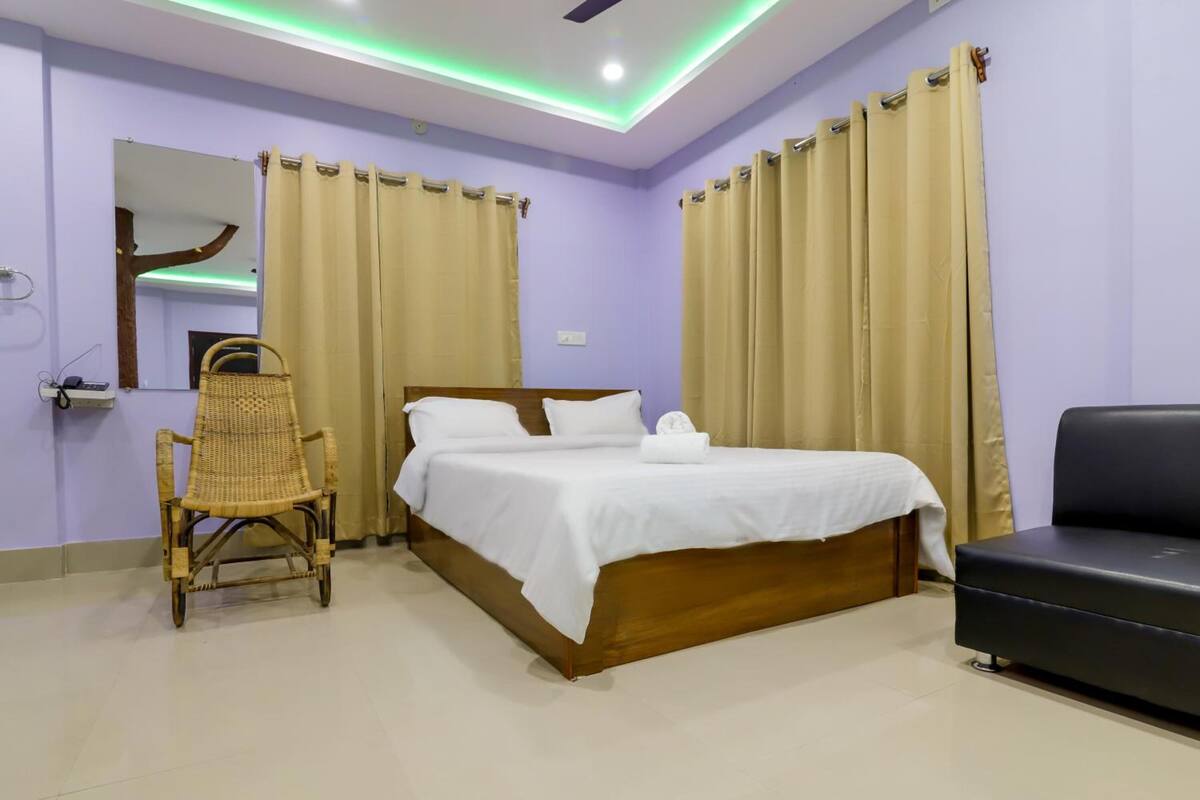 Um quarto com cama, uma cadeira e um sofá.