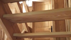 Eine Holztreppe mit Blick auf einen Raum, der Holzwände und eine Tür hat.
