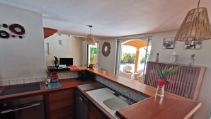 Cocina compacta con encimeras de madera, lavavajillas y fregadero. Hay una ventana que ofrece luz natural y vistas al exterior.