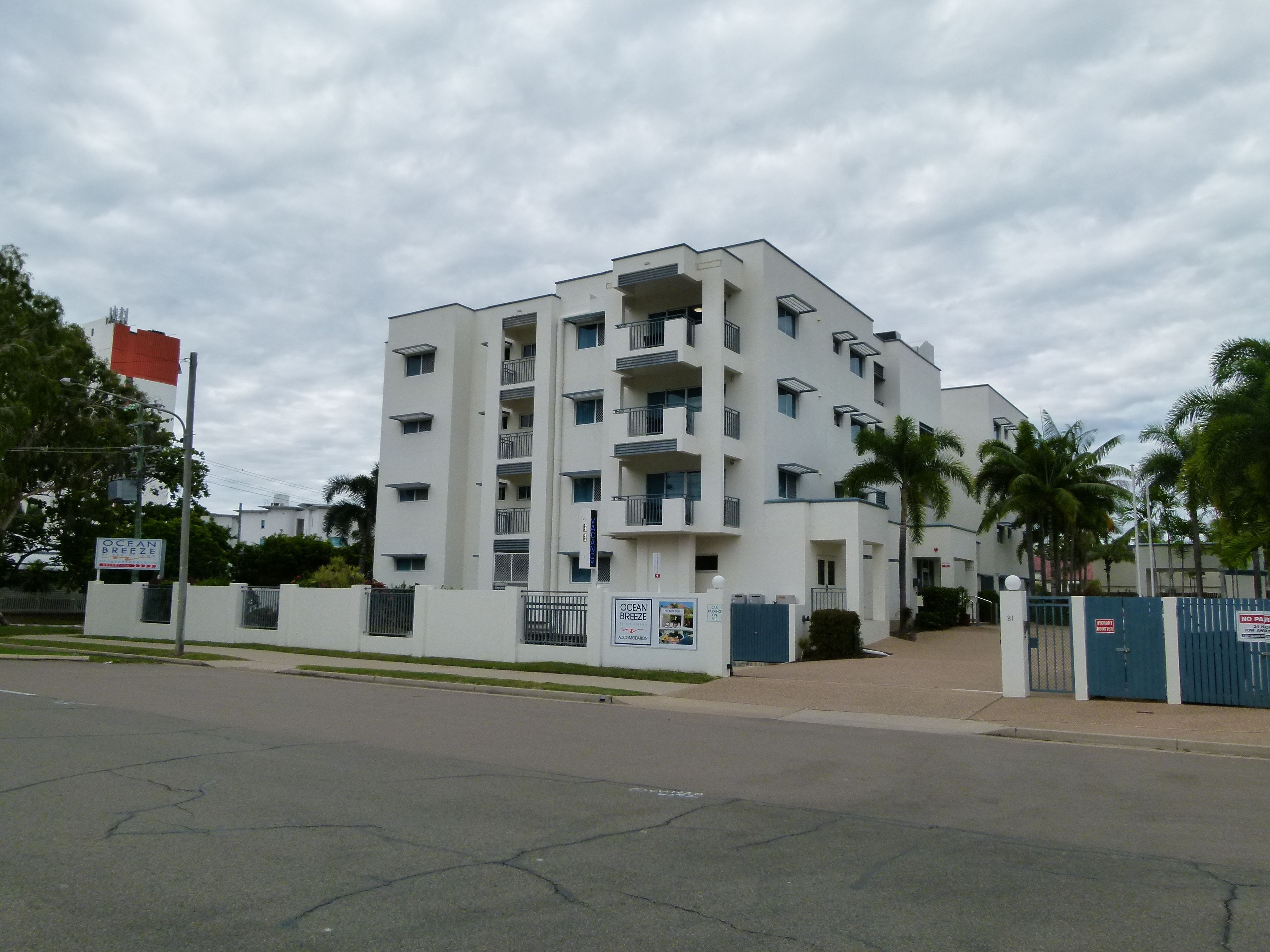 Ein mehrstöckiges Gebäude mit Balkonen, einem verschlossenen Eingang und einem Schild für Ocean Breeze.