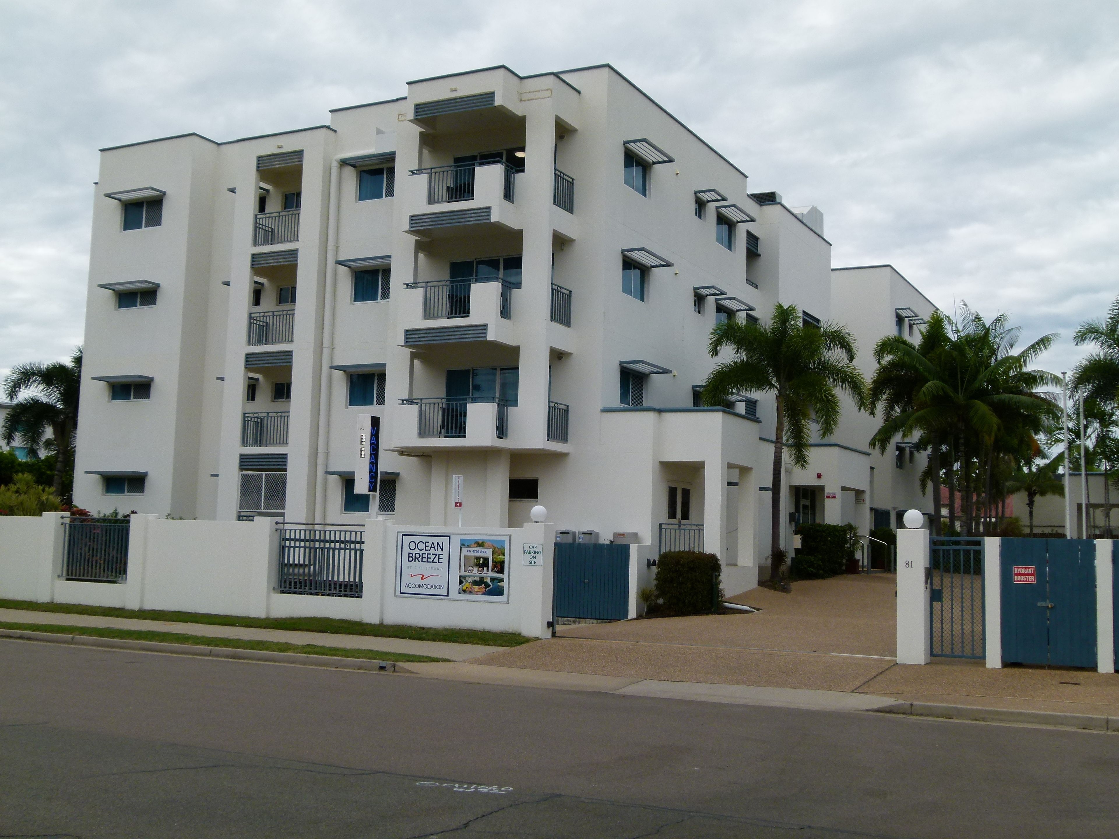 Un immeuble à plusieurs étages doté de balcons, d’une entrée sécurisée et d’une enseigne indiquant qu’il s’agit d’un hôtel.