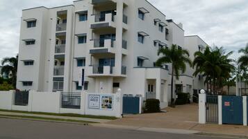 Un immeuble à plusieurs étages doté de balcons, d’une entrée sécurisée et d’une enseigne indiquant qu’il s’agit d’un hôtel.