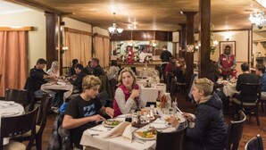 A restaurant with multiple tables and patrons dining.