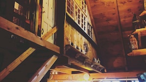 Un interior rústico con vigas de madera, una escalera y un comedor con mesa y sillas.
