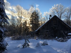 A rustic wooden barn surrounded by snow-covered trees and a clear sky. - Rustic Charm close to Portland (Cumberland)