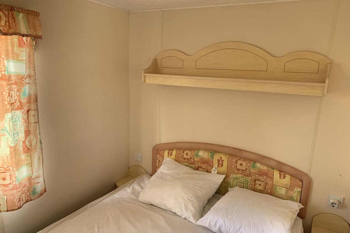 Cozy retreat with a single bed, bedside tables, and a floral-patterned curtain.