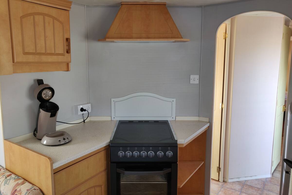 Prepare meals with ease in this kitchen featuring a gas stove, oven, and coffee maker.