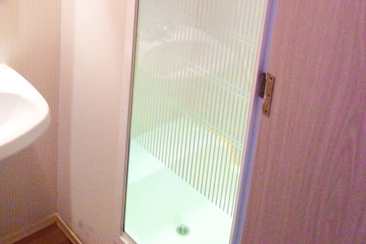 Bathroom features a sink, shower enclosure, and storage cabinet.