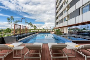 Una piscina al aire libre, sombrillas, tumbonas
