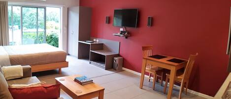Ein Hotelzimmer mit Bett, Schreibtisch, Fernseher und Essbereich.