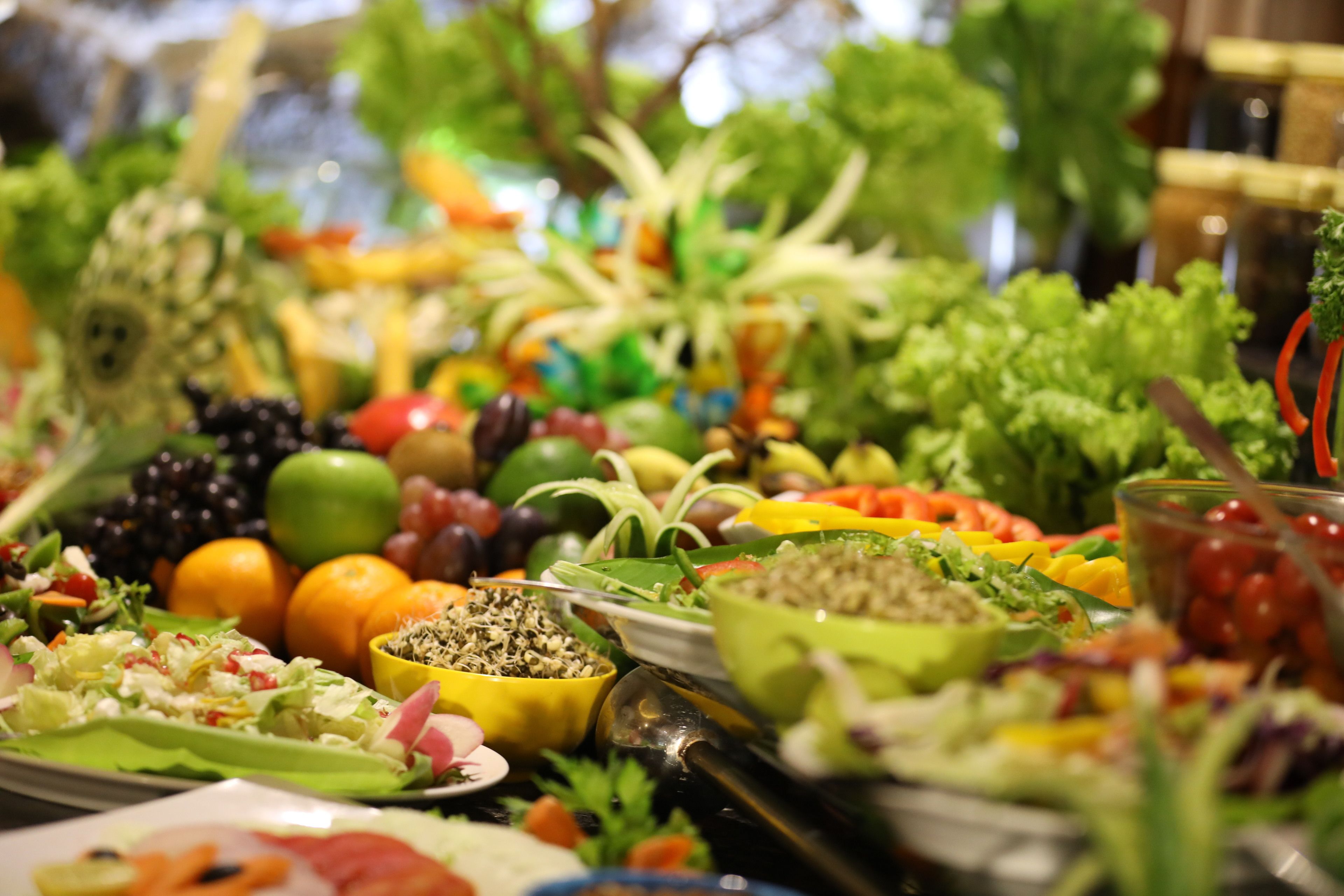 Un buffet proposant une variété de plats, notamment des salades, des fruits et des légumes.