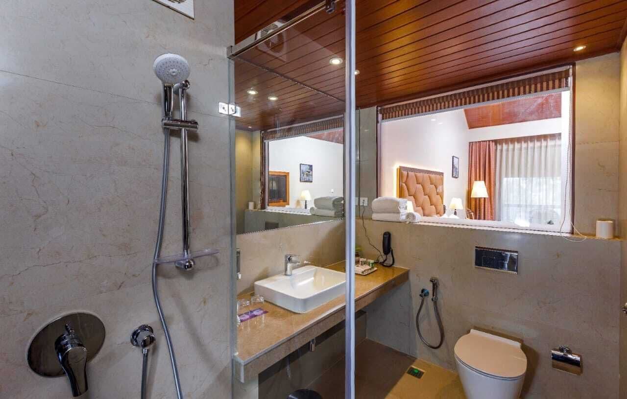 A modern bathroom with a glass-enclosed shower, a sink, and a toilet.