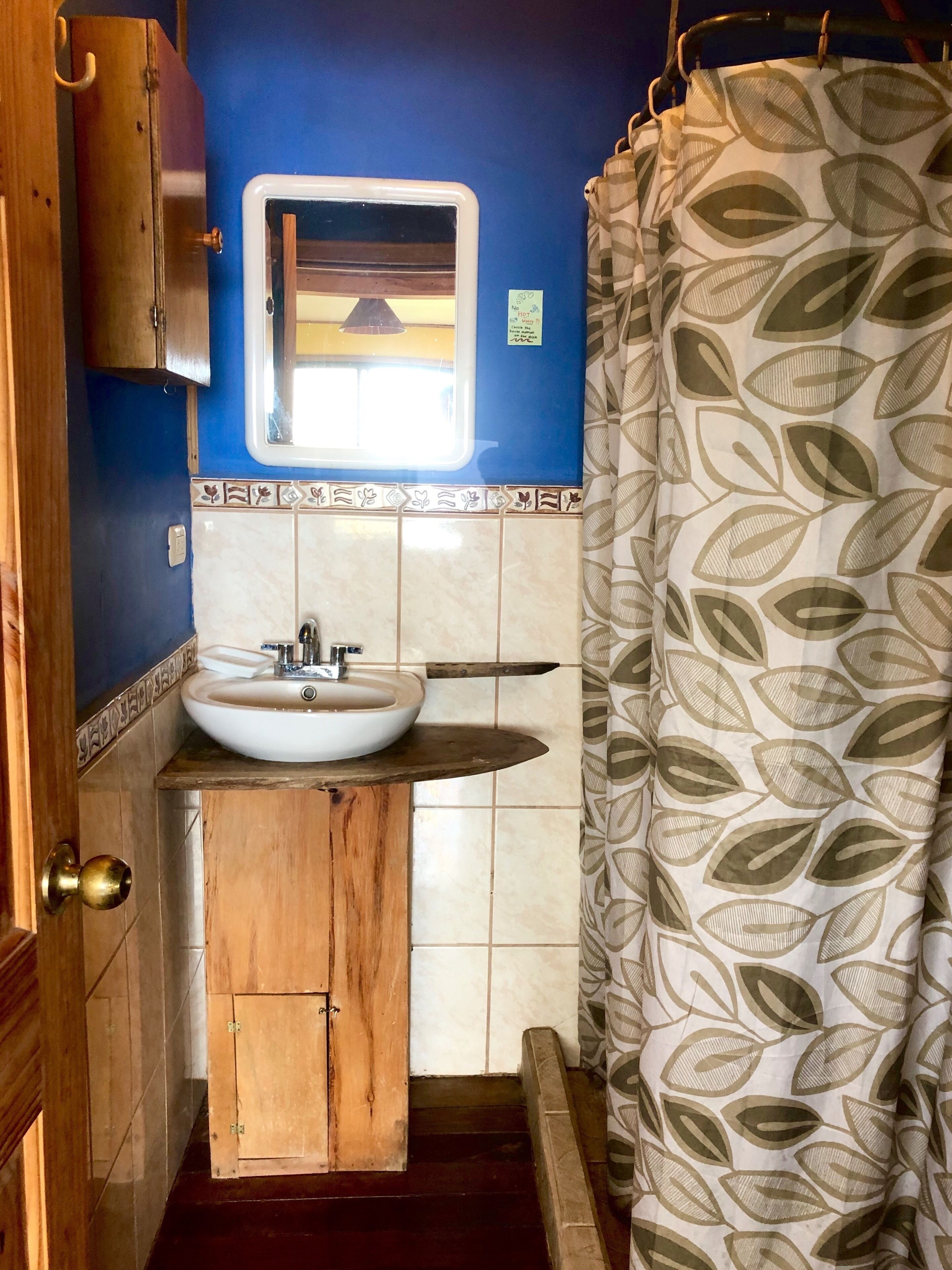 First floor bathroom features custom wood fixtures and a hot water shower