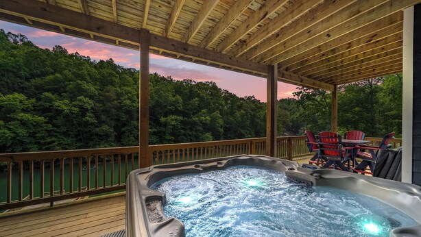 Ein Whirlpool auf einer Holterrasse mit Blick auf eine bewaldete Landschaft.