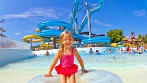 A water park with multiple water slides and a pool area. - Braun Rio - Guadalupe River, 2 King Master Suites, Loft, Riverfront Patio (New Braunfels)