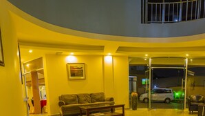Amplia sala de estar con sofá, mesa de centro y puerta de vidrio que da al exterior.