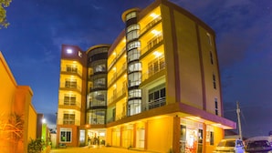 Un hotel de varios pisos con un patio central, balcones en cada planta y una entrada a nivel de suelo con cochera.