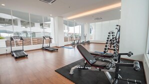 A modern gym with treadmills, a bench press, and weight machines. - Symphony Suite Malacca (Malacca City)