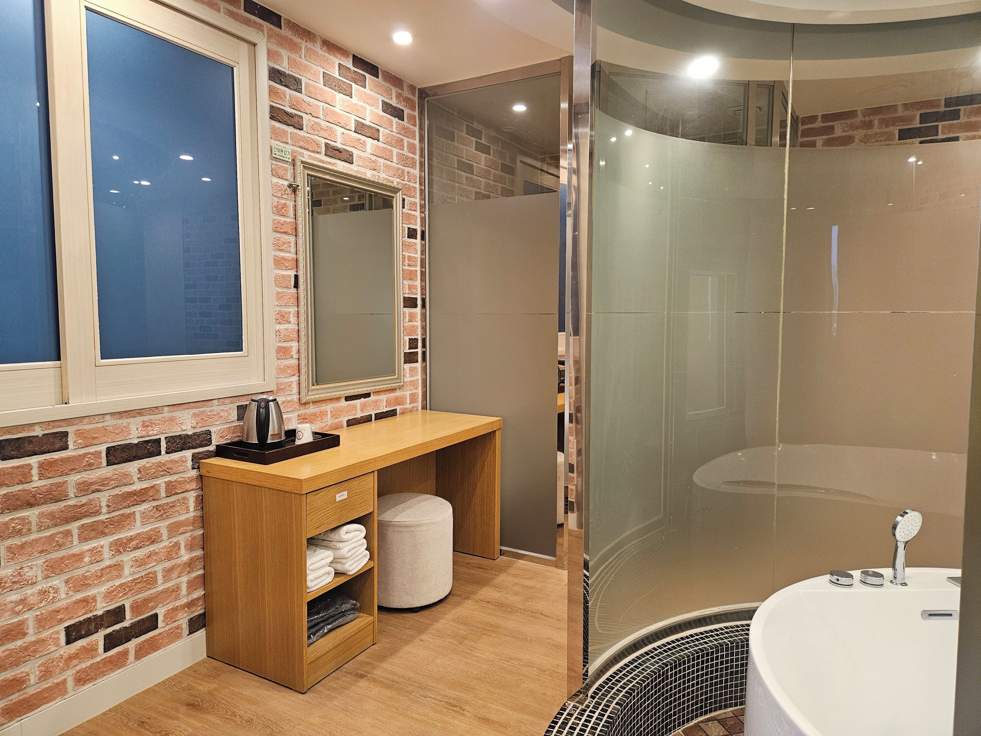 A modern bathroom with a shower, a vanity with a mirror, and a window.